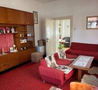 Living room in a family house with a red carpet and wooden furniture.