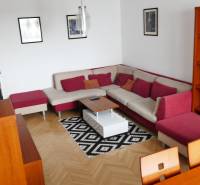 A living room of a three-room apartment with a corner sofa and wooden furniture.