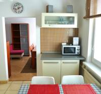 A kitchen in a 3-room apartment with a dining table and a view into the living room.