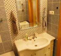 A bathroom with a sink and a mirror in a three-room apartment, tiled with blue and blue-white tiles.