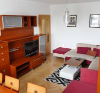Living room in a 3-room apartment with a wooden wall unit and a corner sofa set.