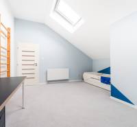 A bright room with a desk, bed, and skylight in a 4-room apartment.