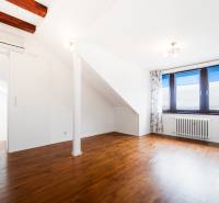 An attic room with a wooden floor and a skylight in a 4-room apartment.