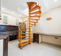 A kitchen with a wooden spiral staircase and a work surface in a 4-room apartment.