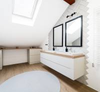 A bathroom in the attic of a 4-room apartment with a skylight and a double sink.