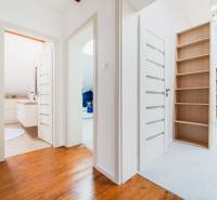 A hallway in a 4-room apartment with a wooden floor, open doors to multiple rooms.
