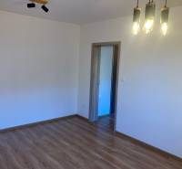 A room with pendant lighting and wooden flooring in a 3-room apartment.