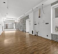Spacious commercial premises with wooden flooring and mirrors on the wall.