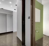 A corridor with tiles and a built-in wardrobe leading to a bathroom in commercial premises.