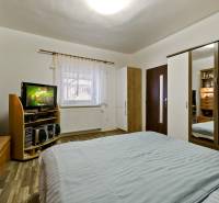 A bedroom in a 2-room apartment with a bed, wardrobe, TV, and wooden furniture.