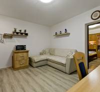 Living room with a sofa, wooden furniture, and shelves in a 2-room apartment.