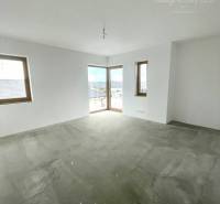 Empty room in a family house with white walls and a concrete floor.