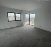 Empty room with windows and concrete floor in a family house.
