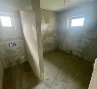 A place for a bathroom with two windows in a family house, ready for renovations.