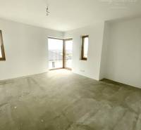 Empty room in a family house with a gray floor and white walls.