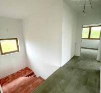 Interior of a family house with concrete stairs and large windows for natural lighting.
