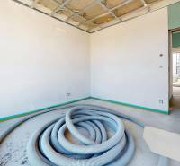 Construction in a family house with hoses on the floor and an open ceiling.