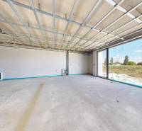 An unfinished interior of a family house with a large window, waiting to be completed.