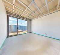 Interior in a family house with an unfinished ceiling, large window, view of the yard.
