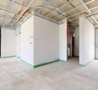 Unfinished interior in a family house with an exposed ceiling and concrete floor.