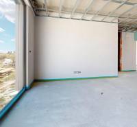 Interior of a family house with a view of the exterior and an unfinished space.