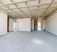 A spacious interior of a family house with unfinished floors and ceiling construction.