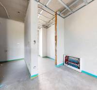The interior of a family house under construction with exposed electrical wiring and white walls.