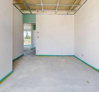 The interior of an unfurnished room in a family house with a view of the outside landscape.
