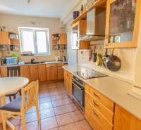 A kitchen in a 4-room apartment with wooden cabinets, a table, and ceramic tiles.