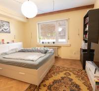 Bedroom in a 4-room apartment with a bed, carpet, and floor with wooden decor.