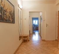 A hallway in a 4-room apartment with laminate flooring and a picture on the wall.
