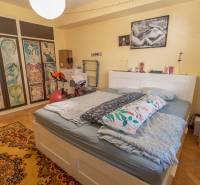 Bedroom in a 4-room apartment with a large bed, decorative pictures, and a wooden decor floor.