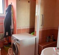 A bathroom in a 3-room apartment with a washing machine and a shower.