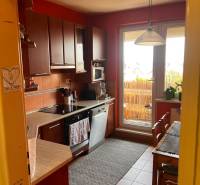 A kitchen with wooden cabinets and a dining area in a 3-room apartment.