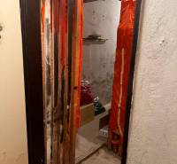 Small room with a shelf, boxes, and curtains, part of a 3-room apartment.