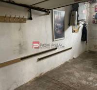 Garages with white walls, a hanger, and shelves, ideal for storage and organization.