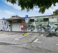 Garages on Pionierska Street in Bratislava III with graffiti and a parking lot.