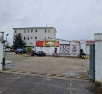 Convoy Truck Shop building on Šamorínska Street, surrounded by parked cars near the warehouse and halls.
