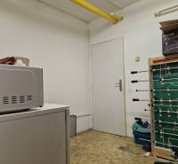A small room with white walls, a gaming table, and equipment on Šamorínska Street.
