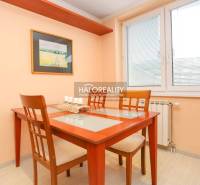 Dining room in a 2-room apartment with a wooden table and chairs, painting on the wall.