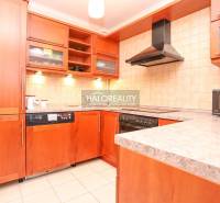 A kitchen in a 2-room apartment with a wooden cabinet and appliances, including a microwave.