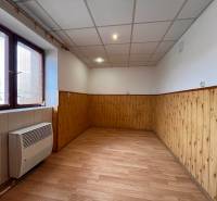 A room with wooden paneling, laminate flooring, and a window in a 2-room apartment.