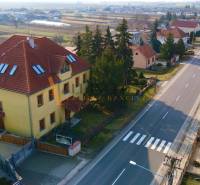 A building on Chrabrany Street in Topoľčany, surrounded by houses and trees, by the main road.