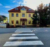 The building on Chrabrany Street in Topoľčany, opposite the pedestrian crossing and trees.