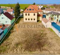 A building on Chrabrany Street in Topoľčany, surrounded by houses and a garden.