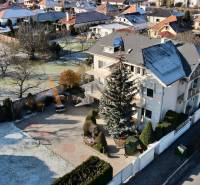A villa on Sportsmen Street in Topoľčany, surrounded by greenery and a white fence.