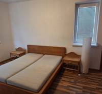 Bedroom in a 2-room apartment with a wooden bed and nightstands.