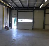 Industrial hall with large doors, steel structure, and lighting, suitable for warehouses.