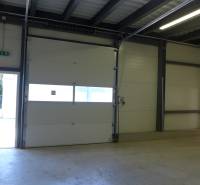 Interior of a warehouse with large garage doors and lighting. Warehouses and halls.