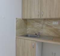 Kitchen corner in warehouses and halls with wooden cabinets and a sink.